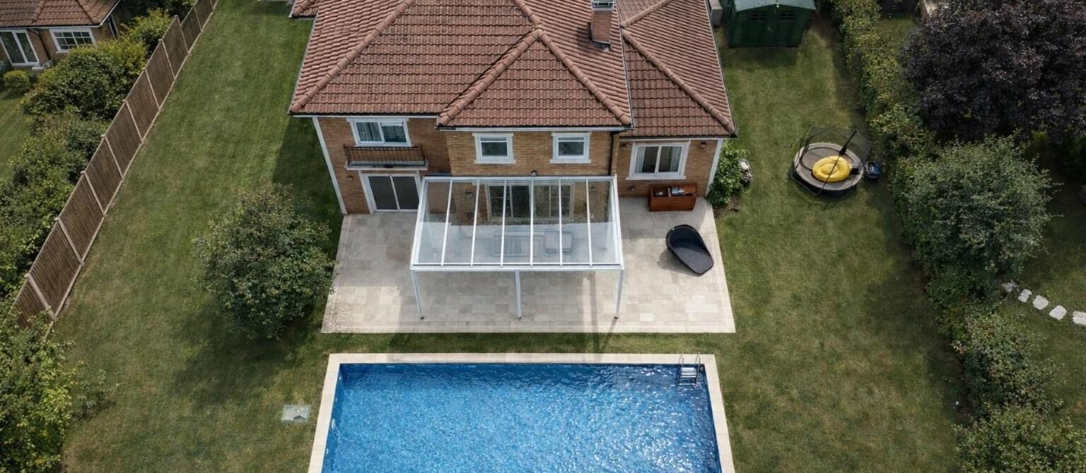 White fixed glass roof veranda over a patio next to a swimming pool, Bowdon, Manchester