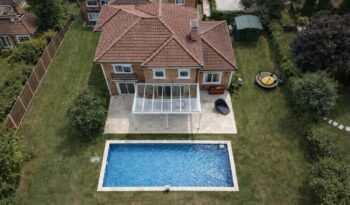 White fixed glass roof veranda over a patio next to a swimming pool, Bowdon, Manchester