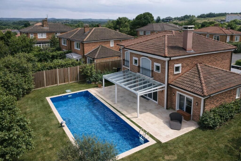 White fixed glass roof veranda over a patio next to a swimming pool, Bowdon, Manchester